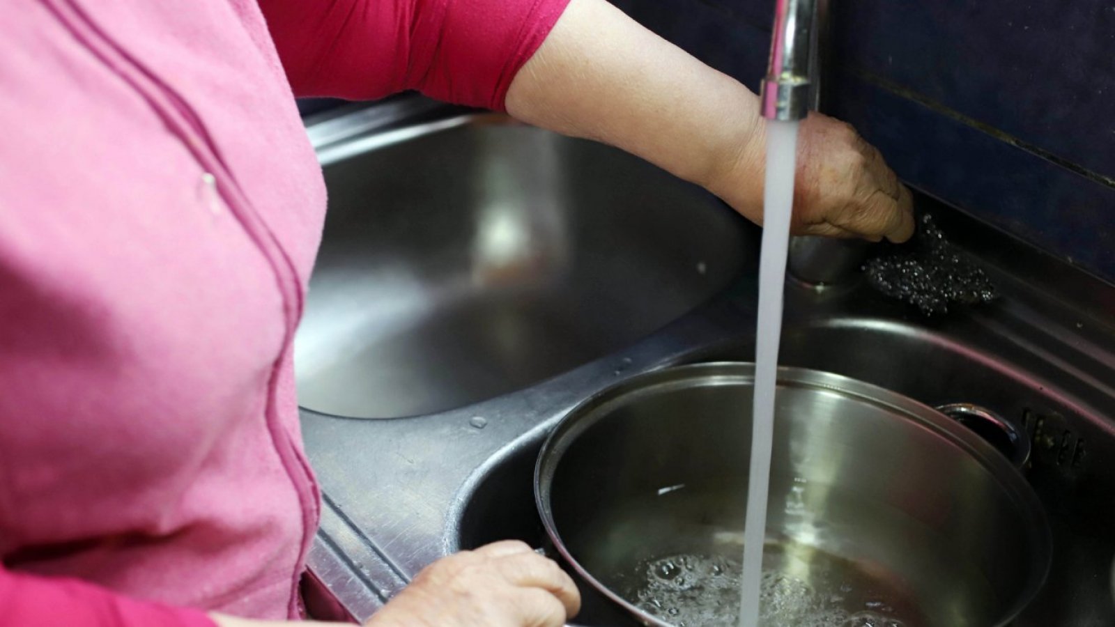 Corte de agua de Esval, mujer llenando una olla.