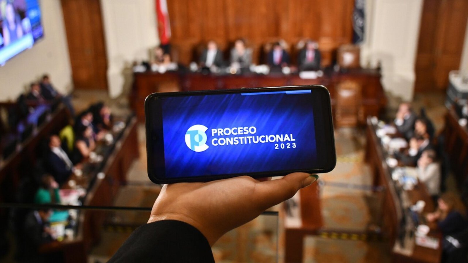 Teléfono con logo del proceso constitucional en sala del Consejo Constitucional.