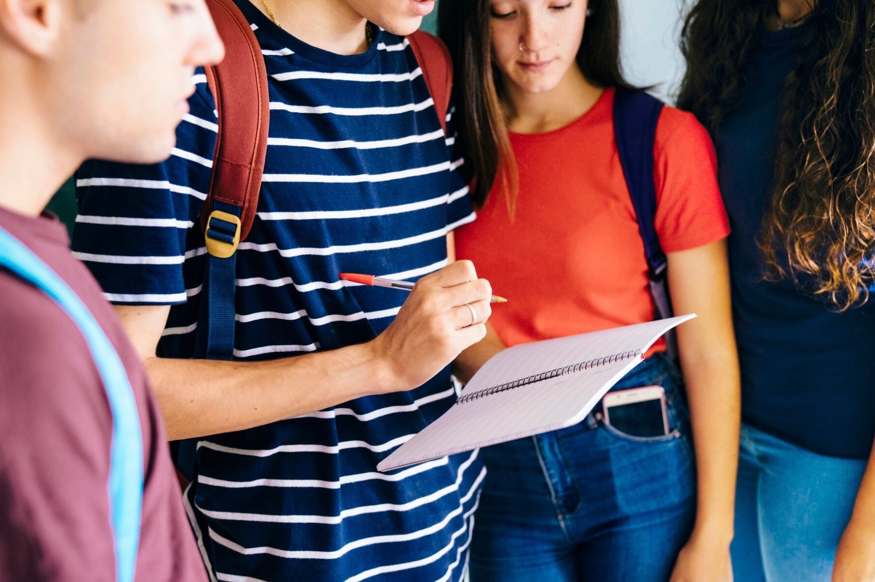 Cuatro universitarios revisando un cuaderno