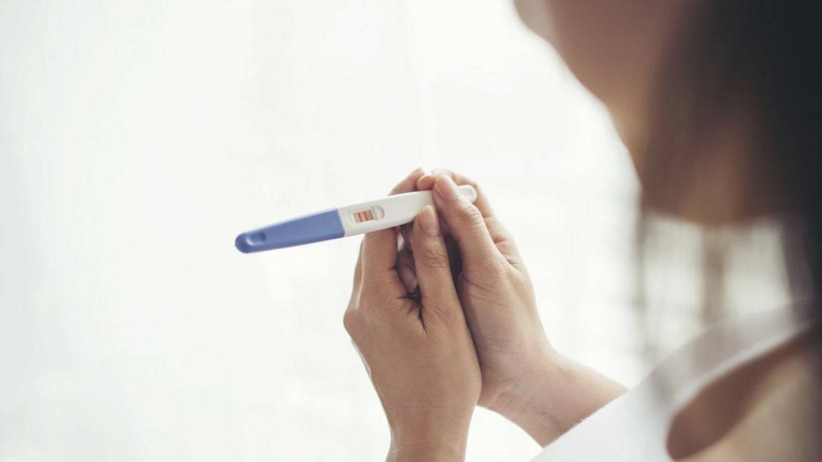 Mujer mirando un test de embarazo.