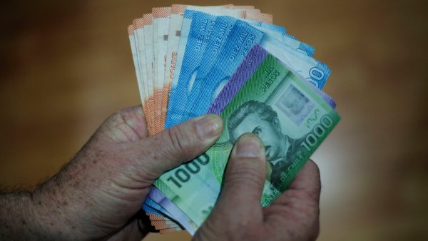 Manos sujetando billetes de todos los valores.