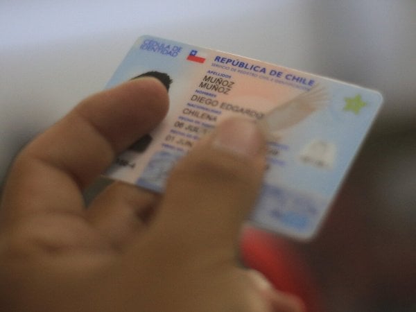 Mano sujetando cédula de identidad.