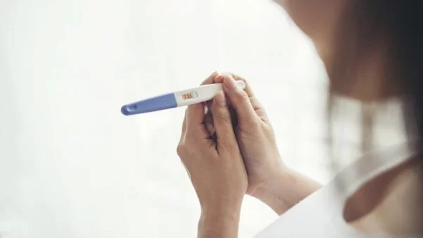 Mujer mirando un test de embarazo.