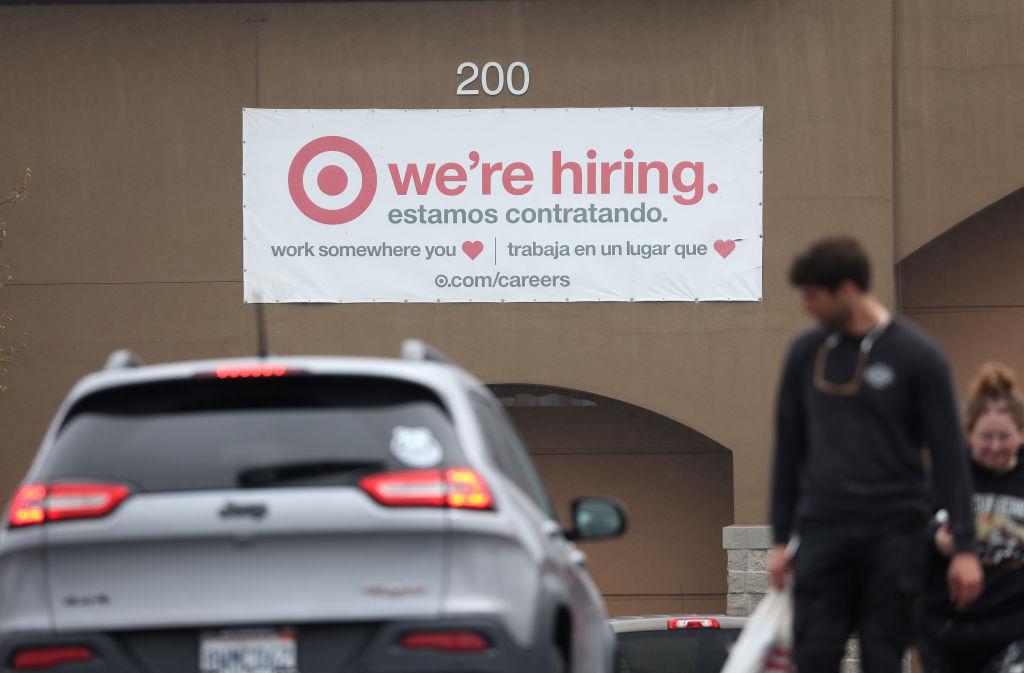 Cartel en inglés y español con aviso de búsqueda de trabajadores afuera de una tienda en California.