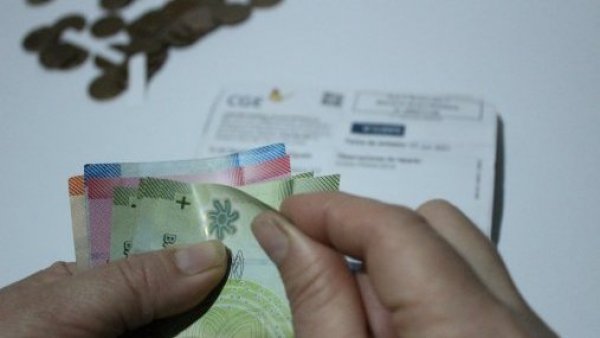 Persona contando dinero en sus manos y cuentas de fondo.