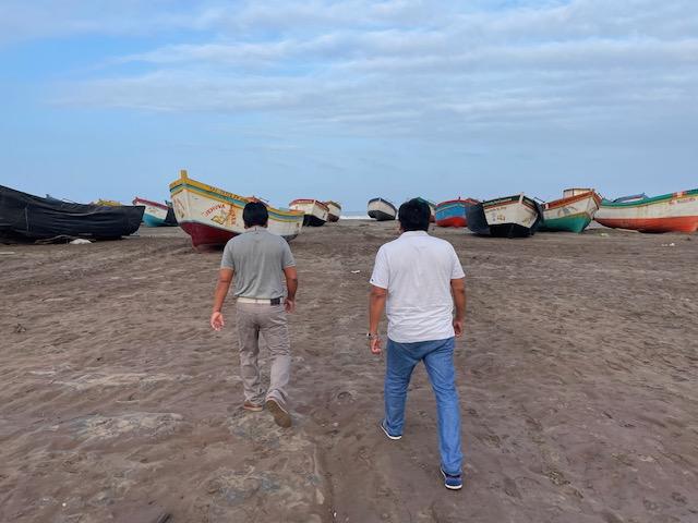 Pescadores caminan entre barcos amarrados en la playa de San José.