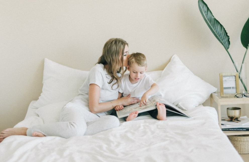 Mujer y niño en una cama.