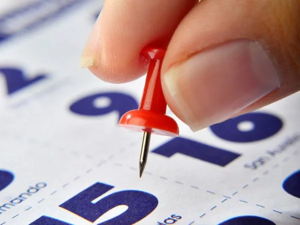 Mano marcando un feriado en el calendario.