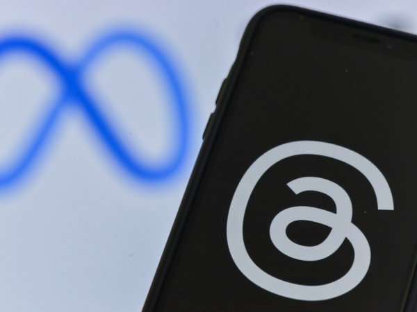 Logo de Meta en un computador y teléfono celular con el logo de Threads.