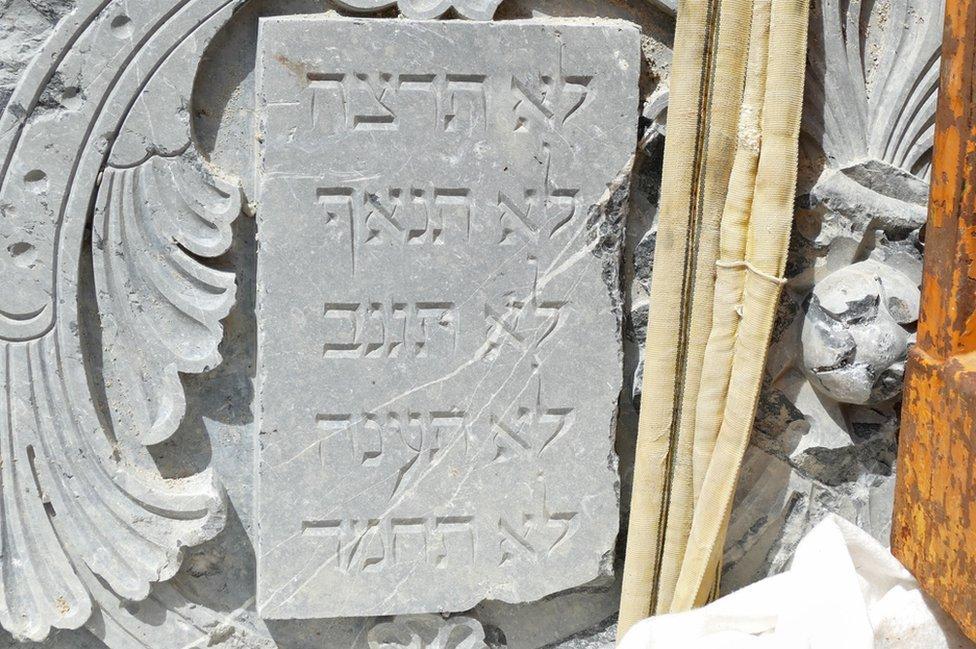 Tablilla rectangular de piedra con letras en hebreo.