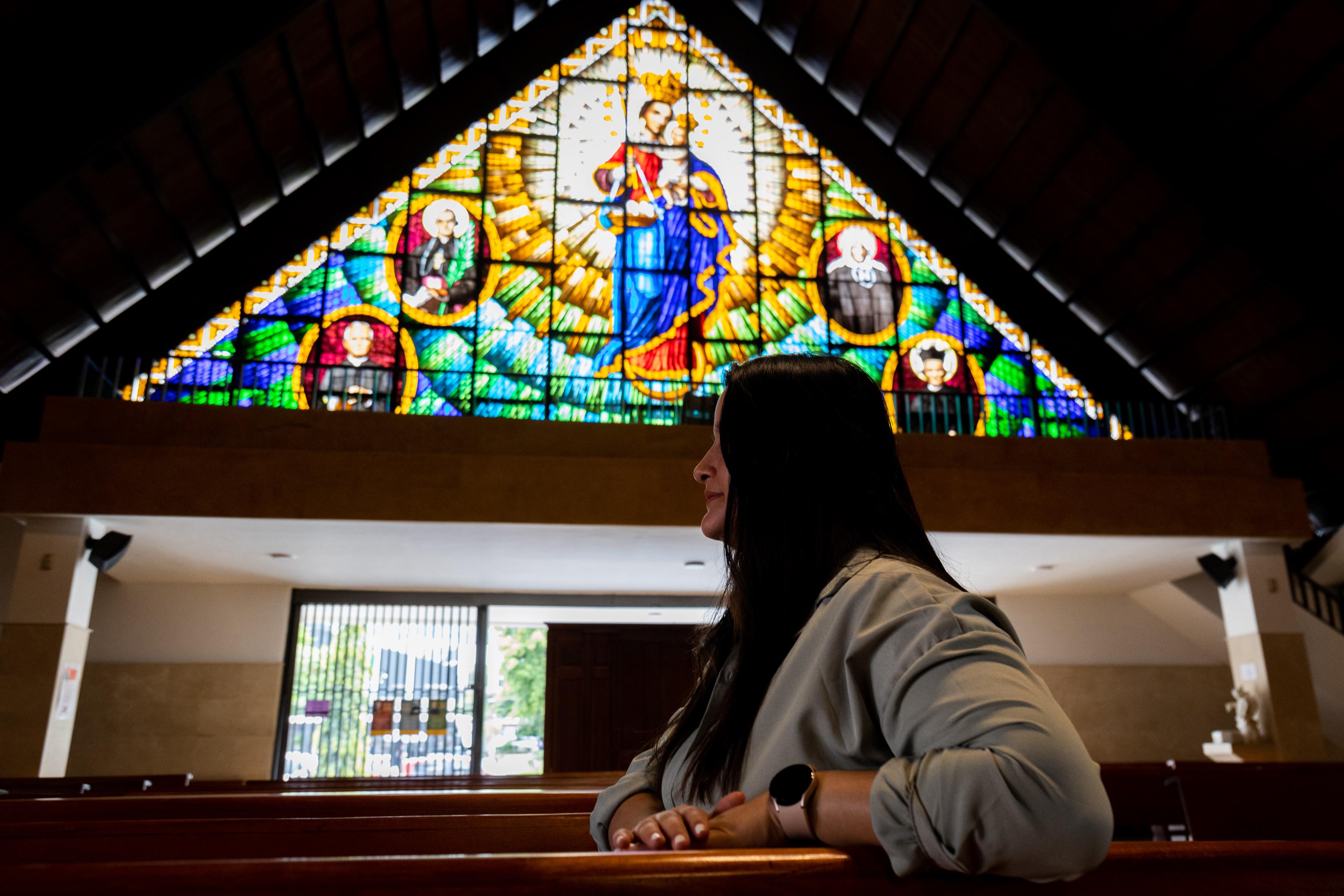 Natalia sentada de perfil en una banca de la iglesia Santa Gertrudis