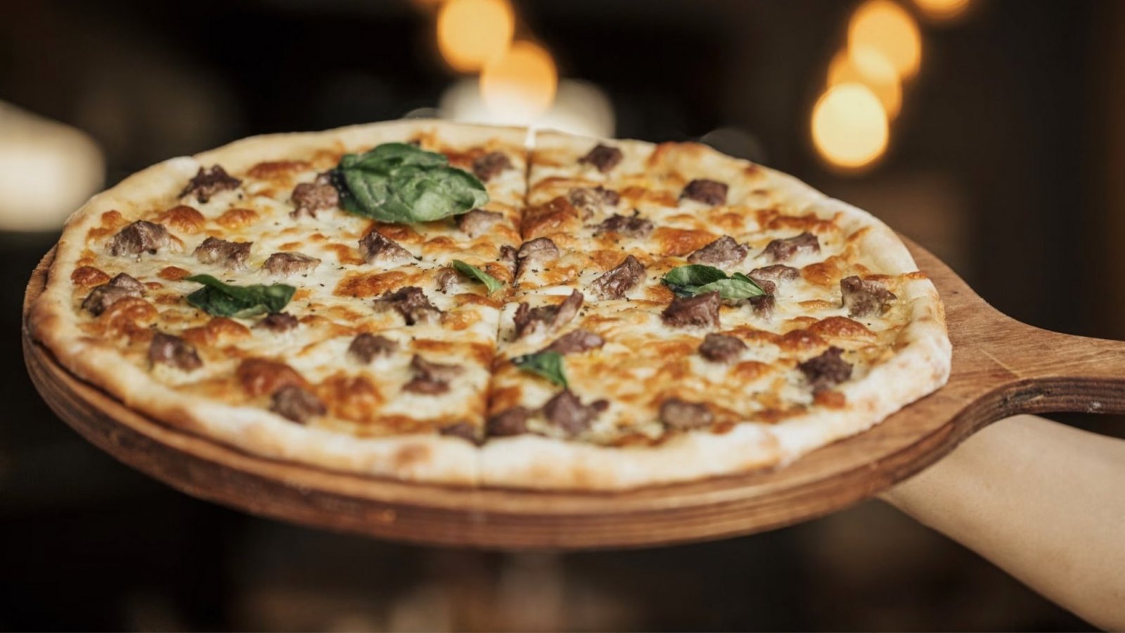 Pizza con diferentes ingredientes en una tabla de madera.