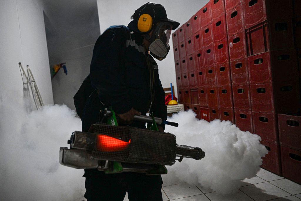 Un operario fumiga un local en Piura, Perú.