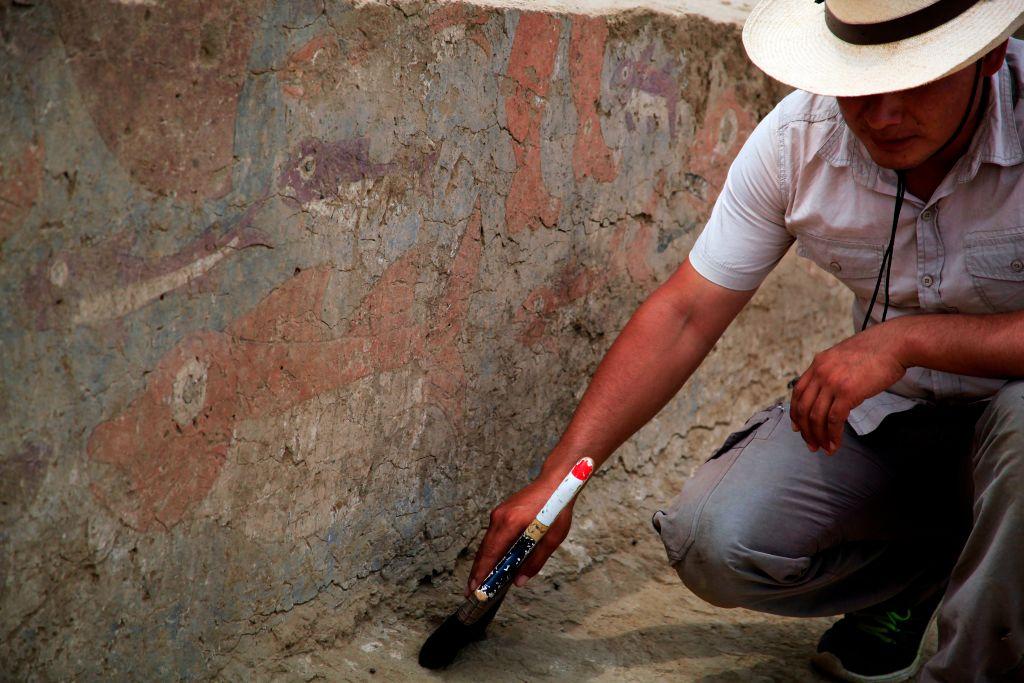 Un arqueólogo trabaj arrodillado en un yacimiento