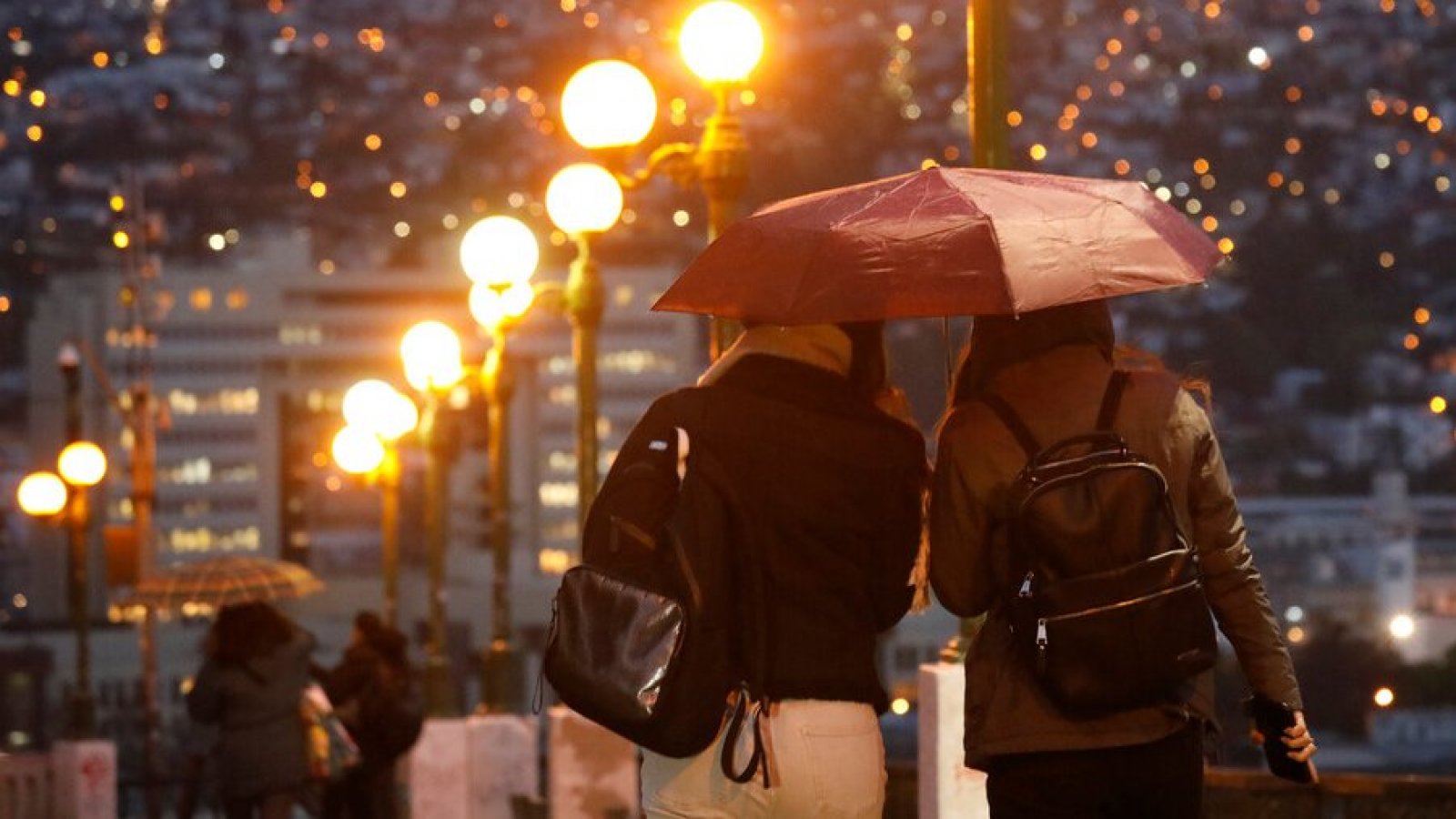 Personas bajo la lluvia con paraguas en Chile