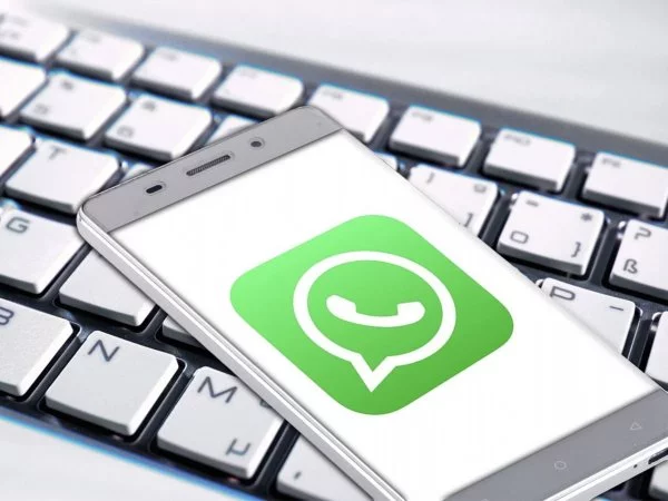Teléfono con el logo de WhatsApp arriba de un teclado.