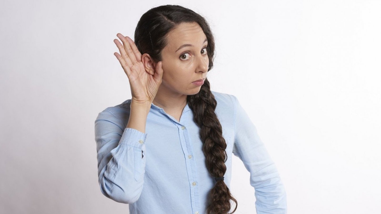 Mujer haciendo como que escucha algo.