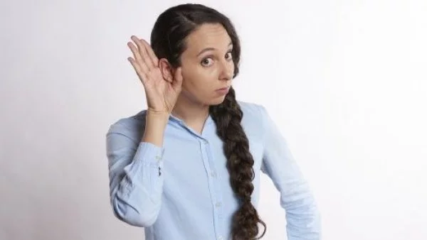Mujer haciendo como que escucha algo.