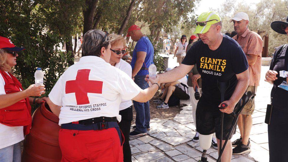 Voluntarias de la Cruz Roja  reparten botellas de agua