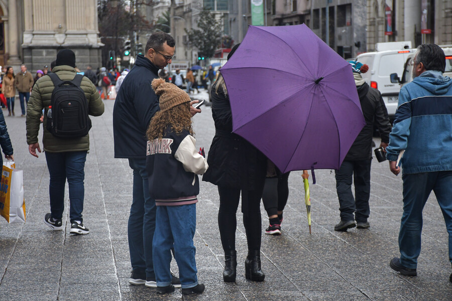 Personas bajo la lluvia en Santiago Centro