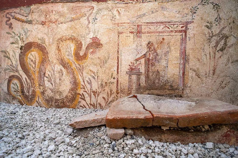 Frescos que muestran una gran serpiente y una figura humana