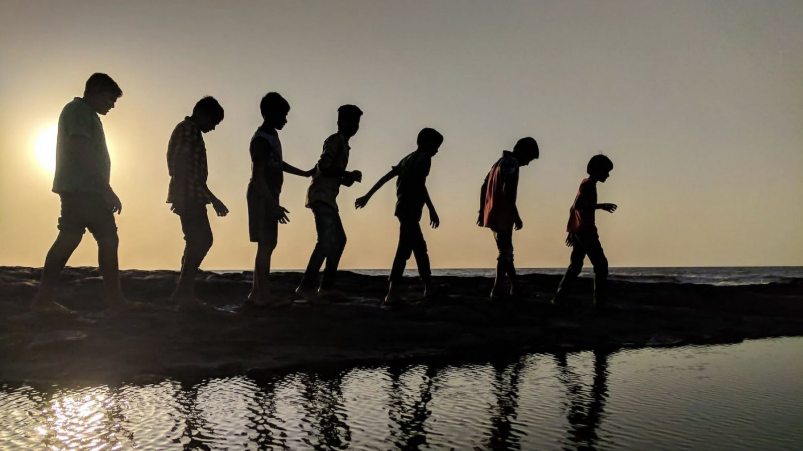 Niños caminando cerca de un lago.