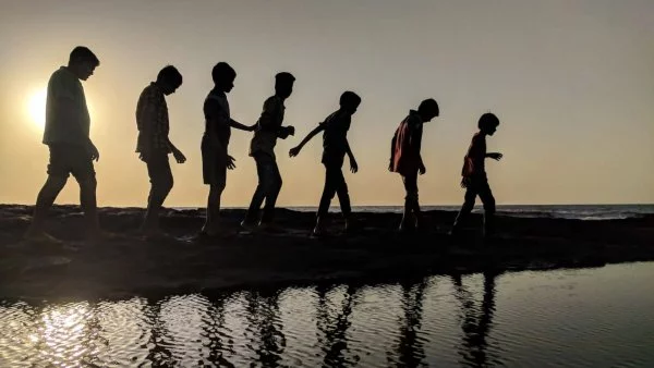 Niños caminando cerca de un lago.