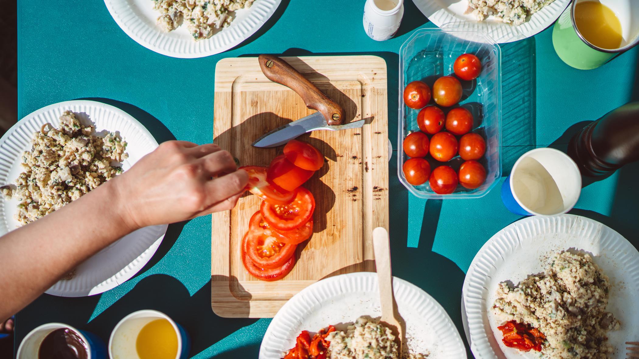 Vista aérea de platos con comida y una tabla con tomates