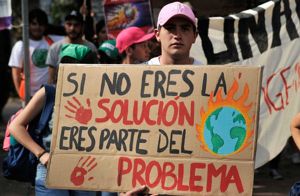 Protesta en México. Un adolescente tiene un cartel que dice "si no eres parte de la solución eres parte del problema"