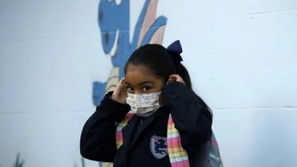 Escolar poniéndose la mascarilla.