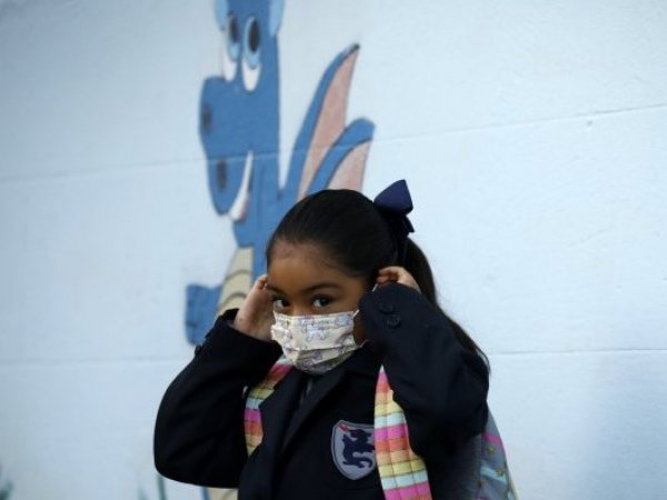 Escolar poniéndose la mascarilla.