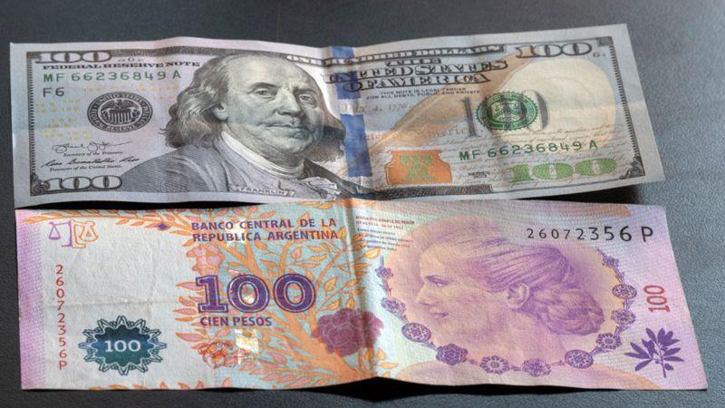 Billetes de100 dólares y pesos argentinos