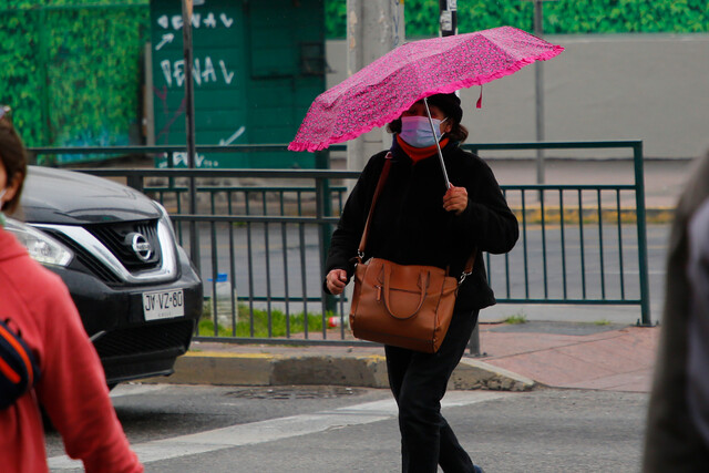 Mujer con paragua bajo chubascos en Santiago