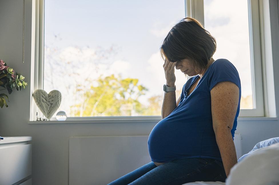 Una mujer embarazada con cara de preocupación 