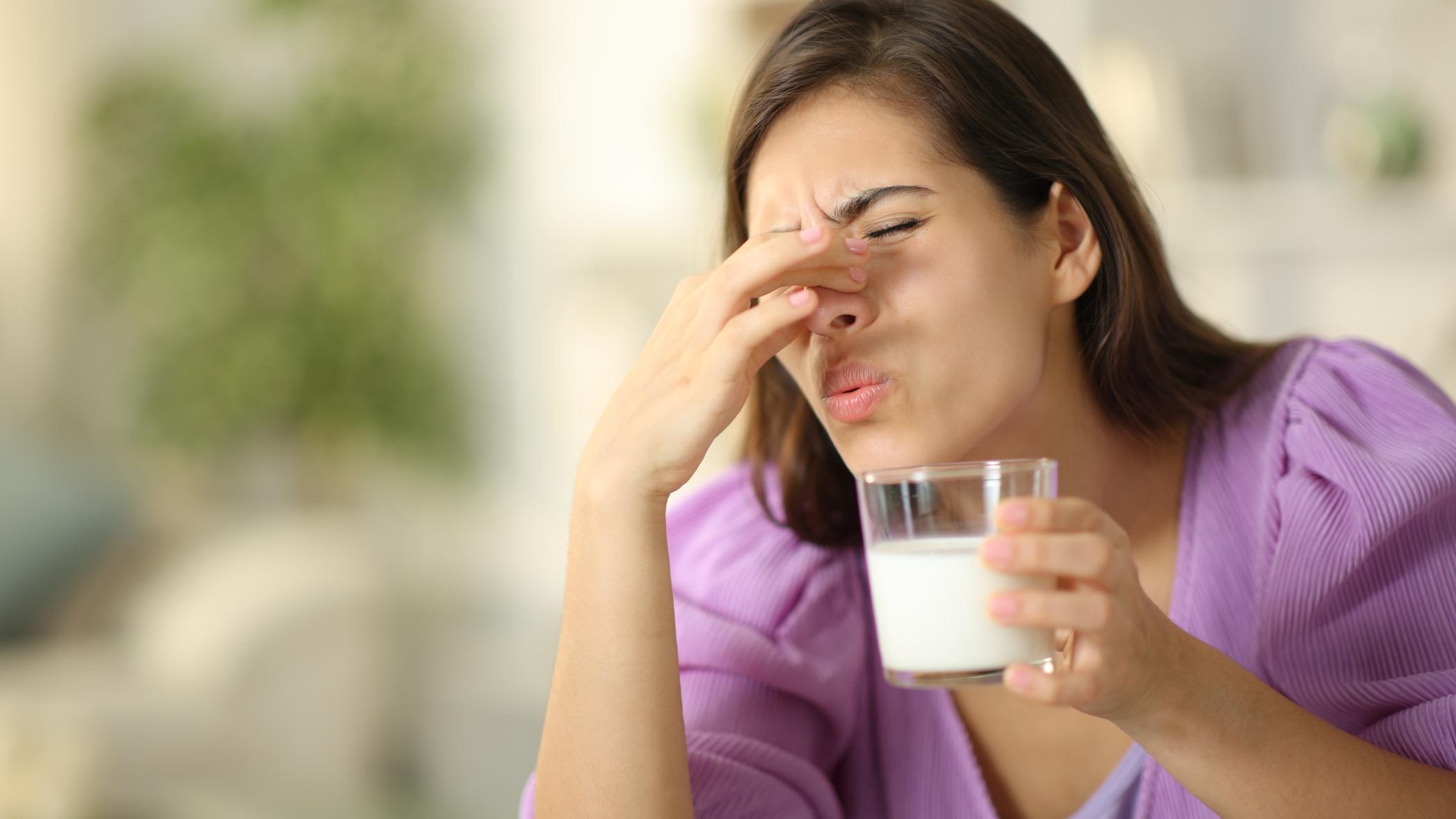 Mujer oliendo un vaso de leche 