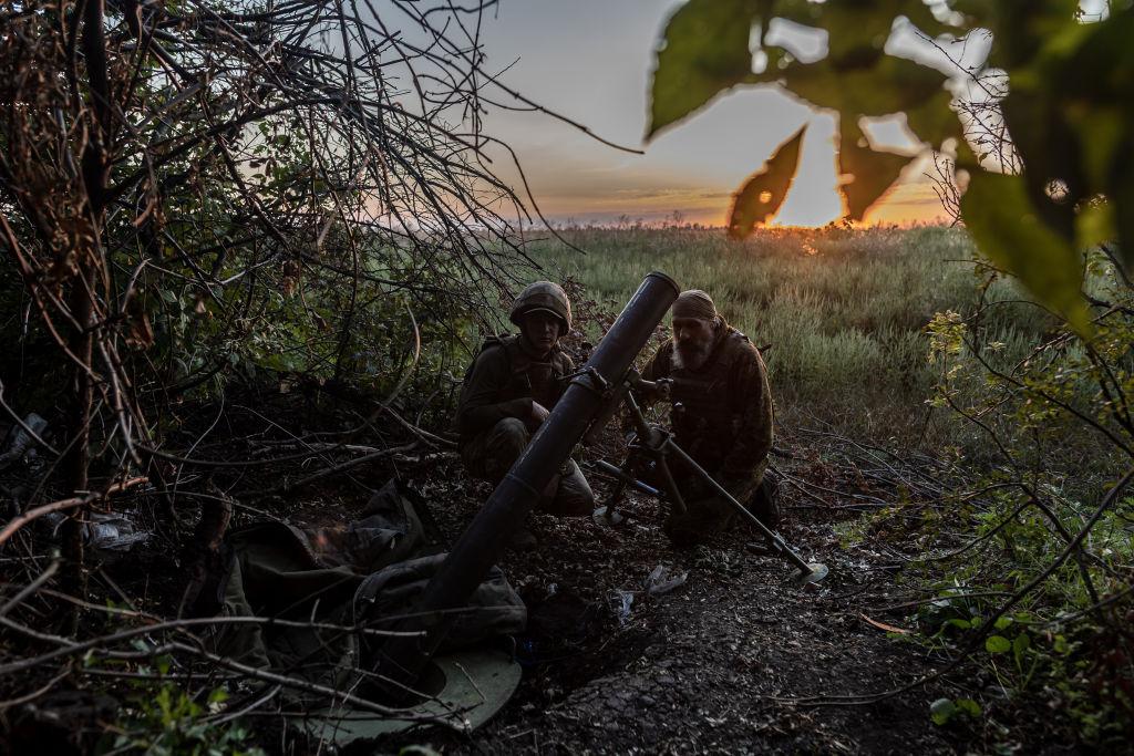 Unos soldados ucranianos en una trinchera junto a un mortero.