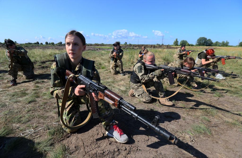 Mujeres soldados practicando con sus rifles.