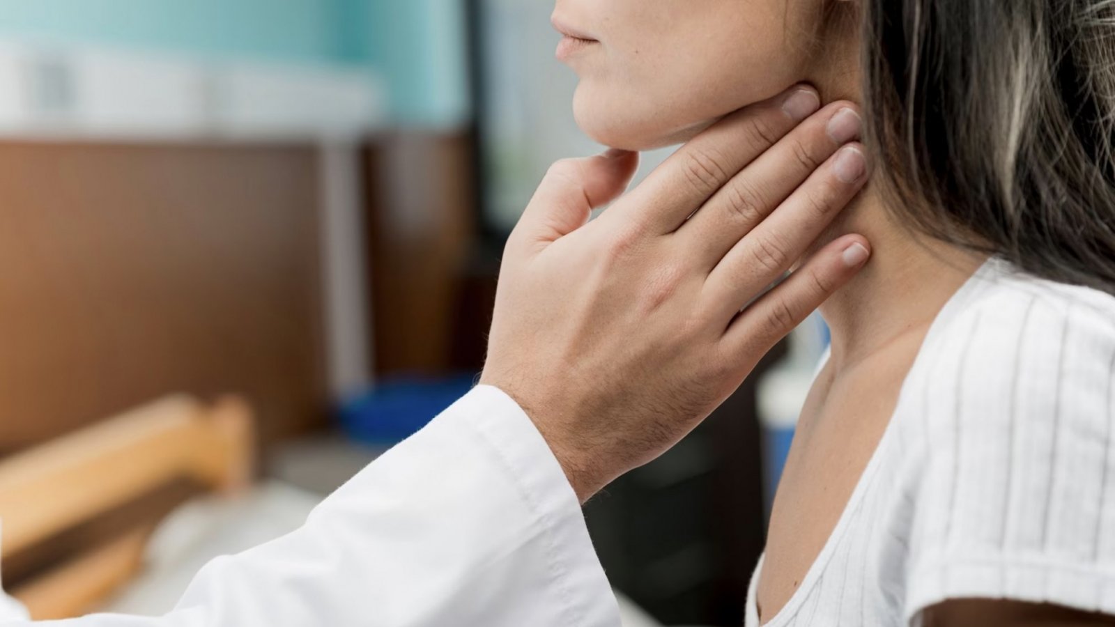 Doctor revisando cuello de una mujer. Hipotiroidismo.