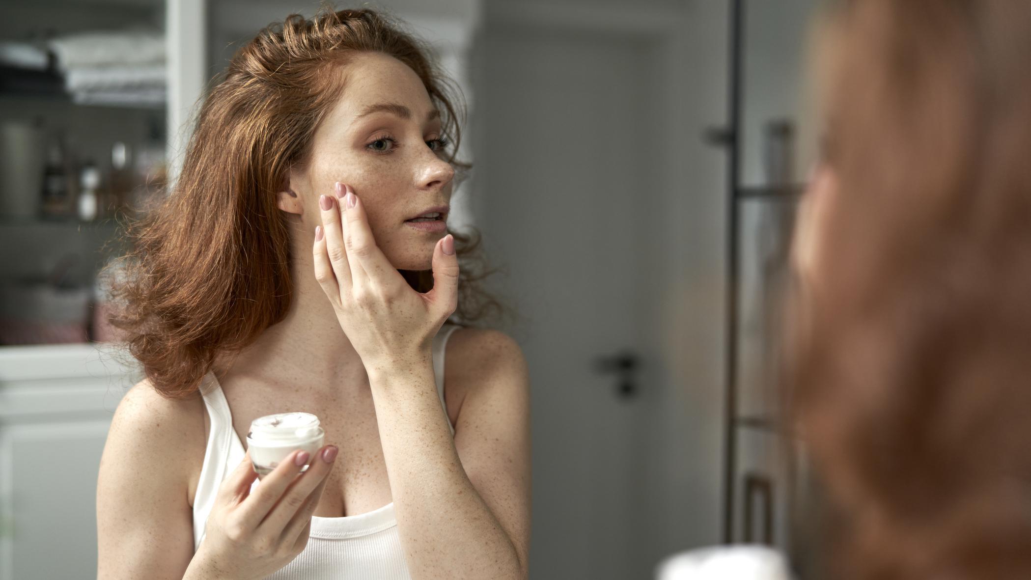 Mujer poniéndose crema 