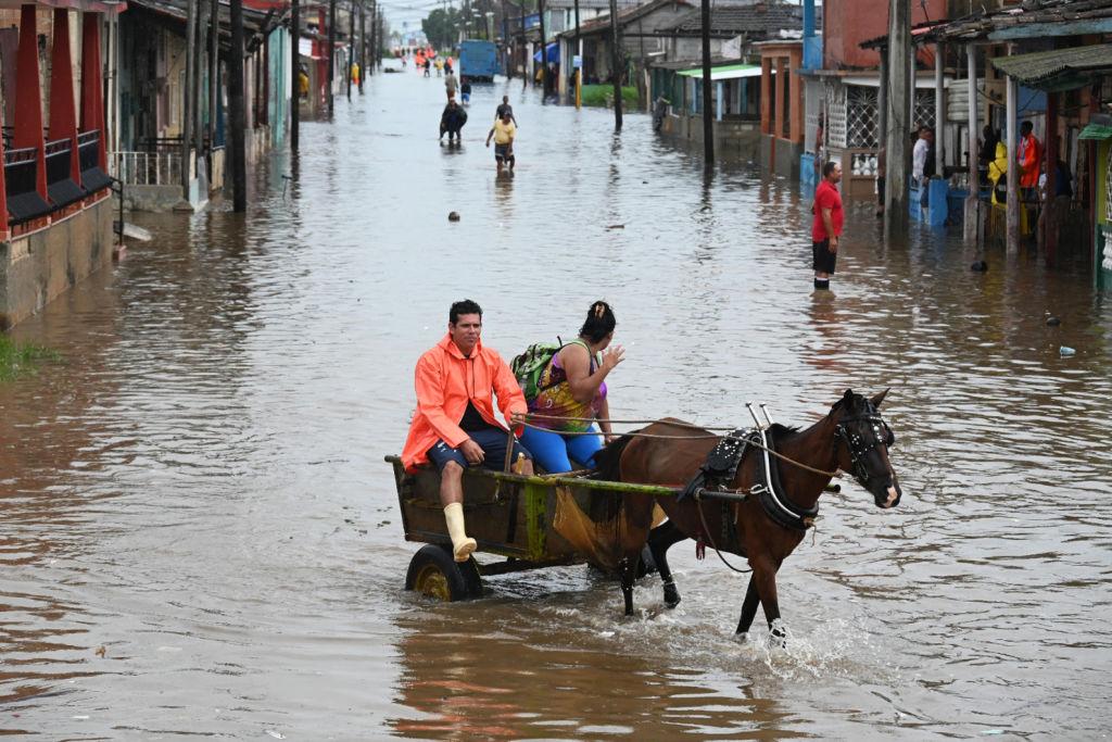 Una pareja viaja en un carruaje tirado por caballos a través de una calle inundada en Batabanó, provincia de Mayabeque, Cuba.