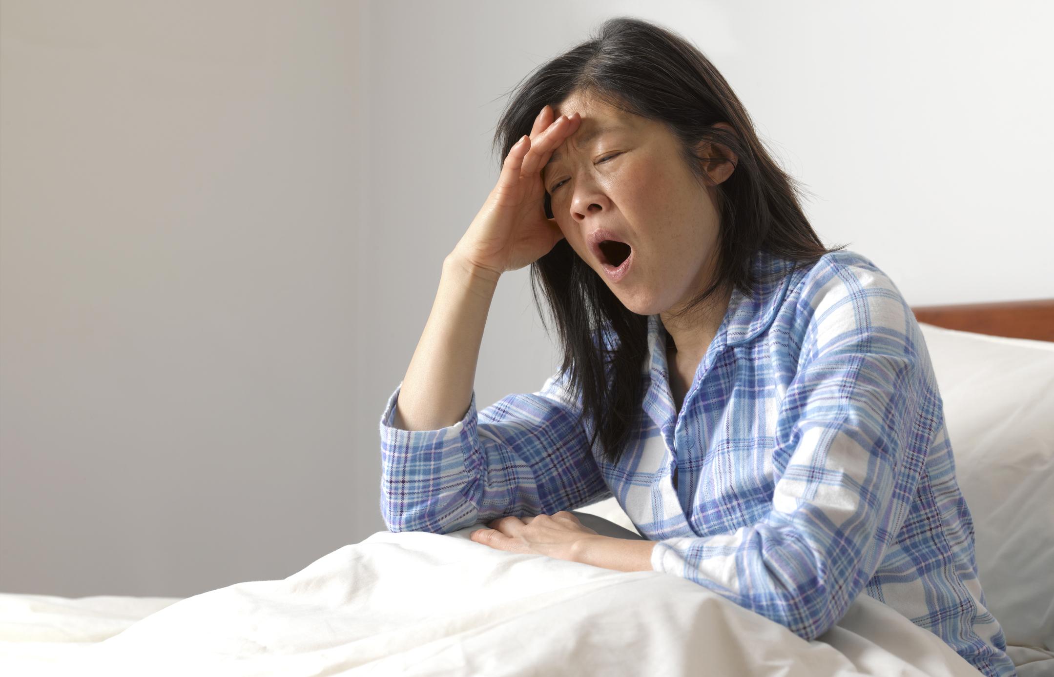 Mujer bostezando en la cama