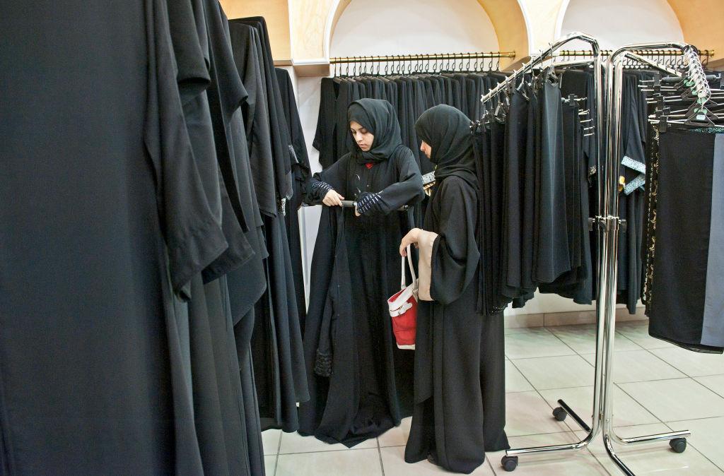 Dos mujeres comprando abayas en una tienda.