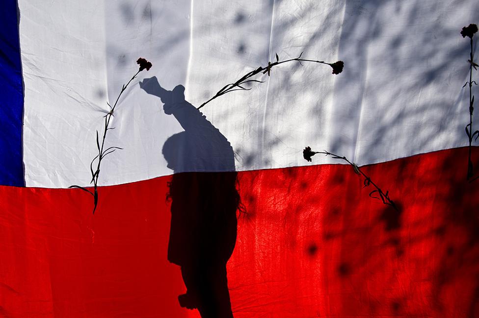 Una bandera de Chile y rosas durante una marcha en Santiago en recuerdo al derrocado presidente Salvador Allende.