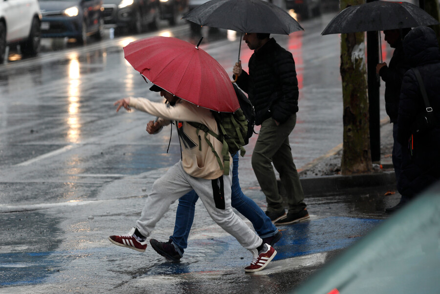 Personas con paraguas bajo la lluvia. Lluvia en Santiago.