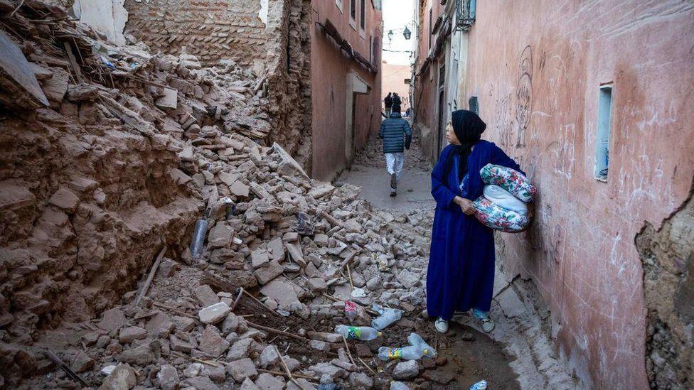 Mujer caminando entre los escombros