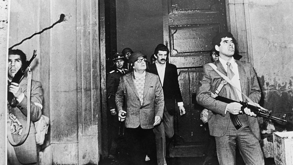 Allende con fusil en mano y casco, en medio del ataque a La Moneda.