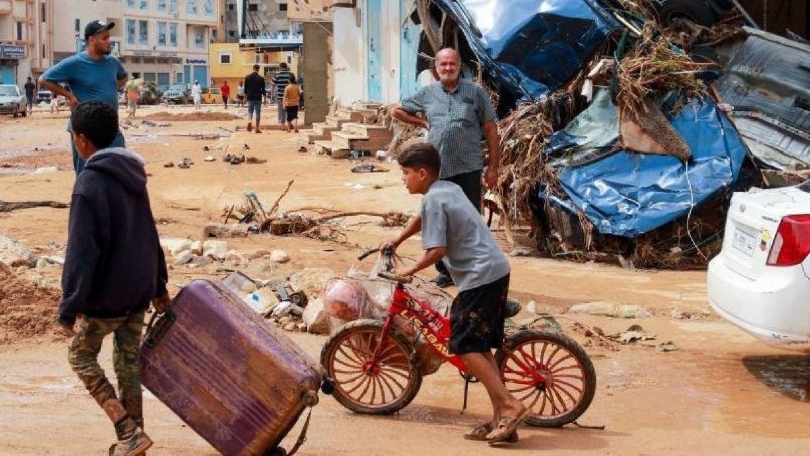 Un niño camina entre el lodo tras las inundaciones en Derna (Libia).