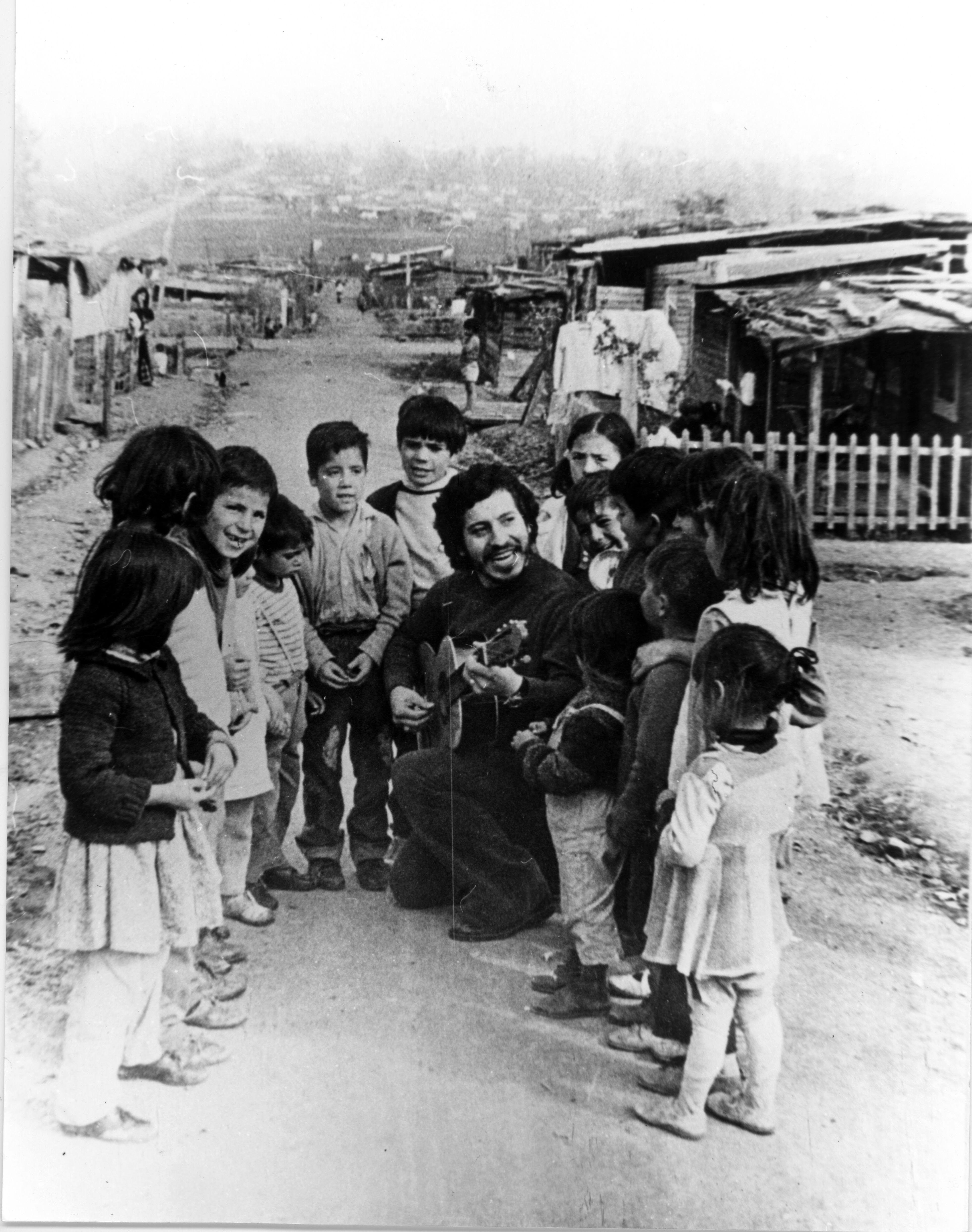 Víctor Jara cantando con niños y niñas en Herminda de la Victoria.