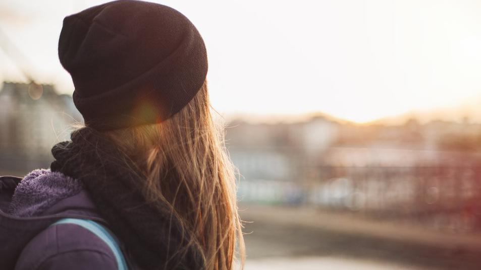 Una mujer de espaldas, mirando a la distancia