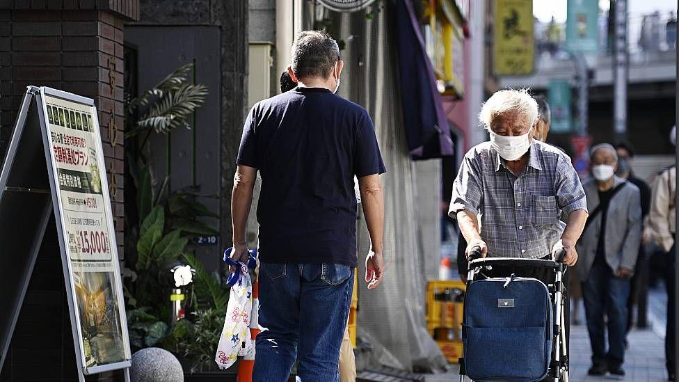 Hombre mayor caminando con un andador en Japón